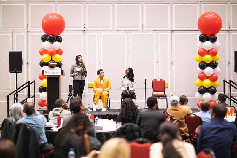 three people on stage with MD Color balloon pillars