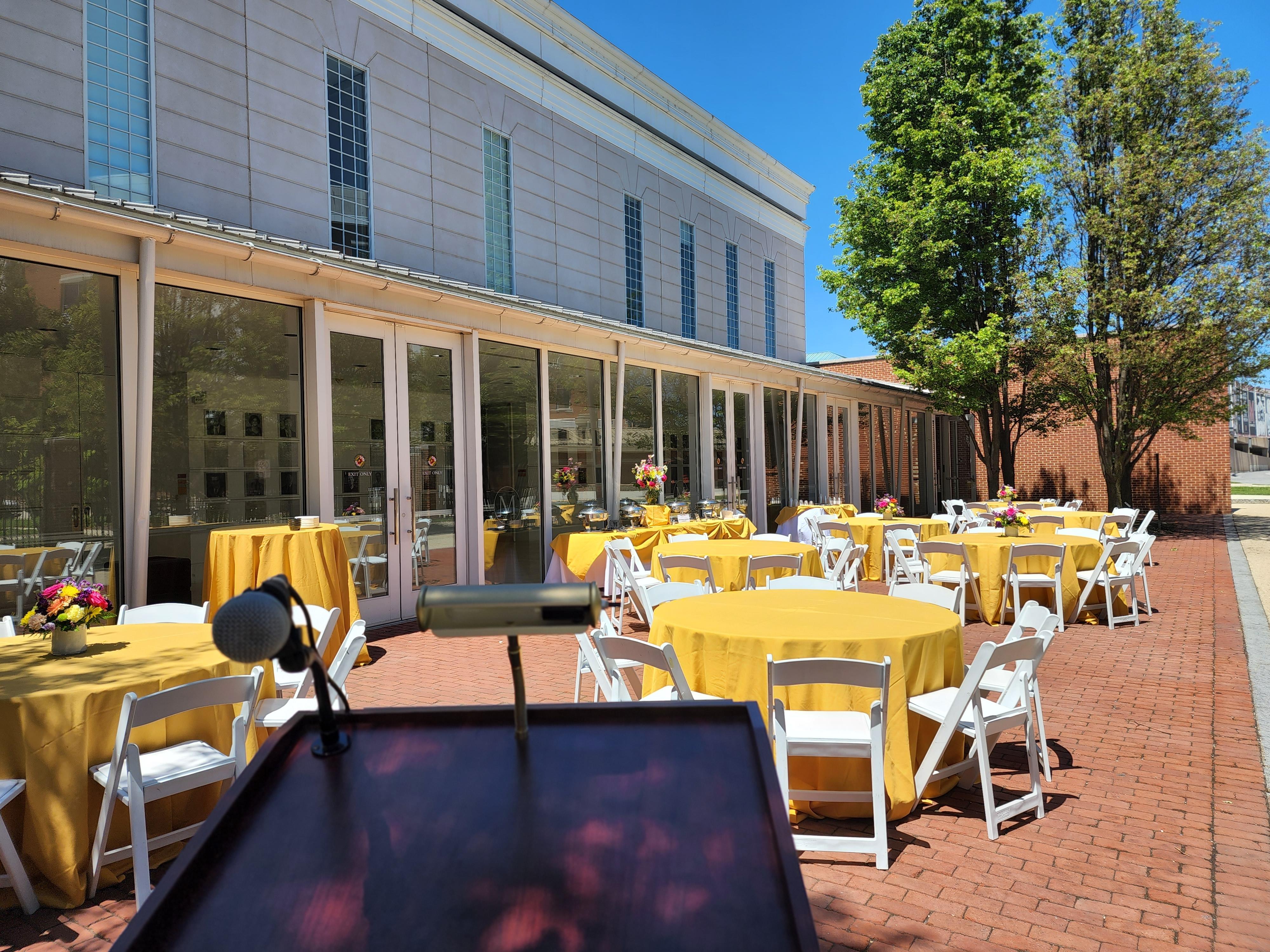 Patio set with yellow linen tables and white folding chairs 
