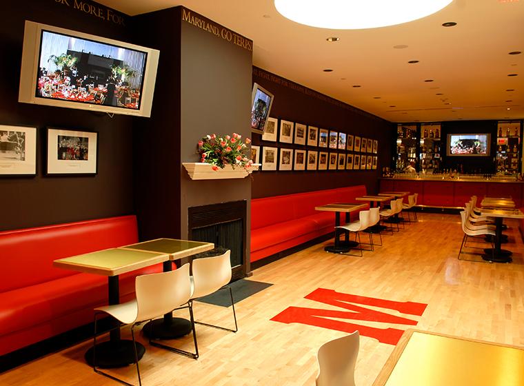Sports club containing red benches, photographic memorabilia and hardwood floors