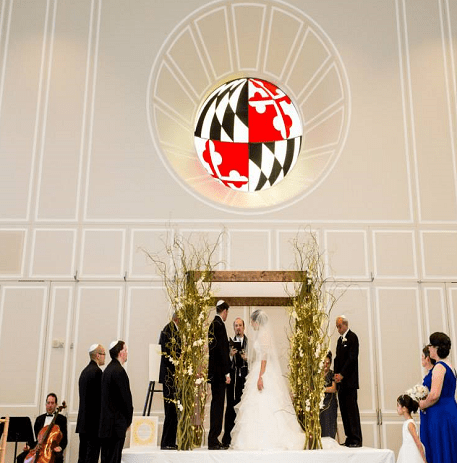Wedding chuppah in front of MD stained glass window